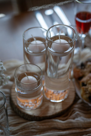 Three glasses of water with floating, unlit candles on the surface.の写真素材