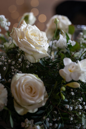 Decorative white rose blossoms in an arrangement, captured in detail at the wedding table.の写真素材