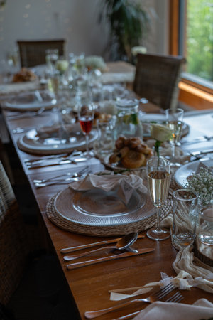 A prepared table for wedding guests with plates, glasses, and decorations.の写真素材
