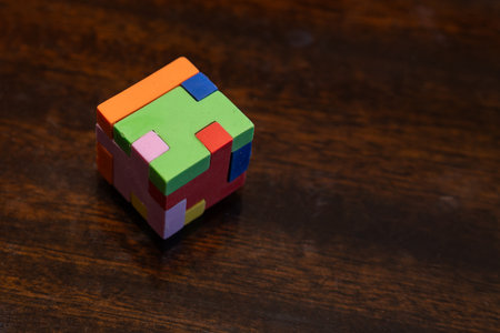 Small colorful puzzle cube, captured in indoor light, highlighting its vibrant sides and compact design as a brain-teasing toy.の写真素材