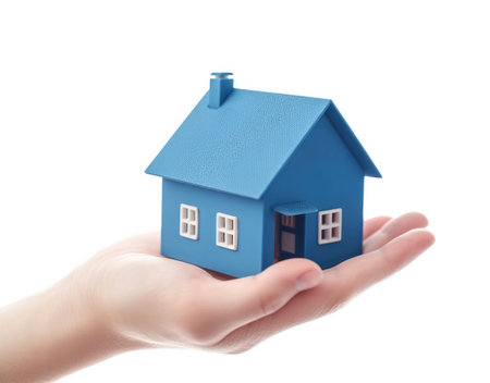 Blue house in hand isolated on a white background. Insurance concept. High quality photoの写真素材