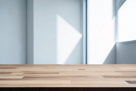 Wooden table in white empty room with window and sunlight.の素材