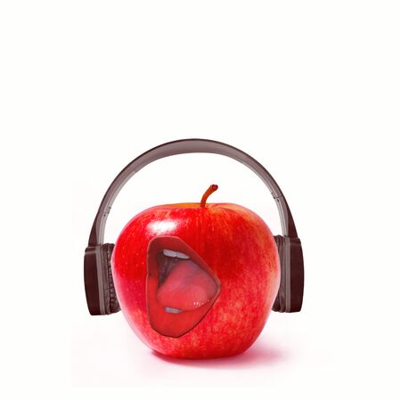 Red apple in black headphones. Opening his mouth wide, sings his favorite songs.