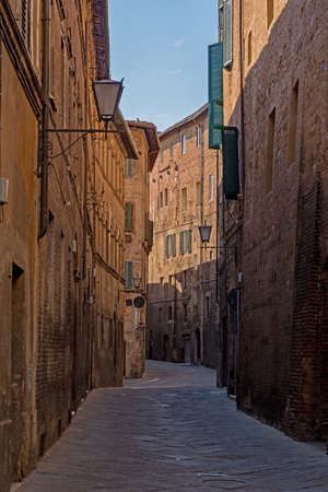 Narrow street at the old town of Siena, Tuscany Region in Italyの写真素材