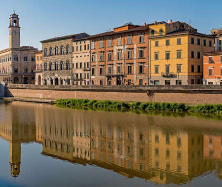 Buildings reflecting at the Arno River at Pisa, Tuscany Region in Italyの写真素材