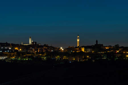 The skyline of Siena's old town at the Tuscany Region in Italy at nightの写真素材