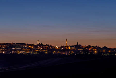 The skyline of Siena's old town at the Tuscany Region in Italy at nightの写真素材