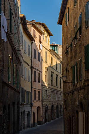 Narrow street at the old town of Siena, Tuscany Region in Italyの写真素材