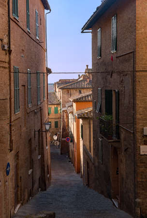 Narrow street at the old town of Siena, Tuscany Region in Italyの写真素材