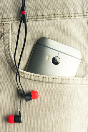Phone and headphone taken out of his trouser pocketの写真素材