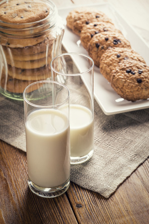Homemade oatmeal chocolate chip cookies and glass of milkの写真素材