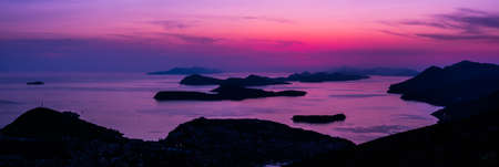 Fantastic and gorgeous colorful sunset panorama overlooking the islands in the Adriatic Sea off the coast of Dubrovnik Croatia making a beautiful background image or landscape photograph.の写真素材
