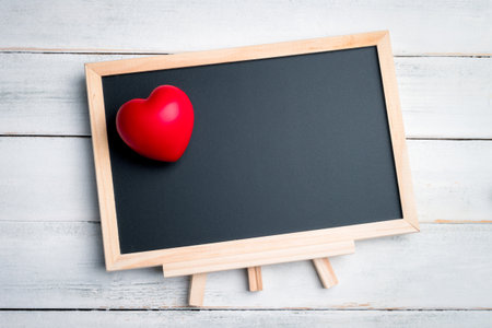 Red heart with blank chalkboard on the white wooden floor valentine festivalの写真素材
