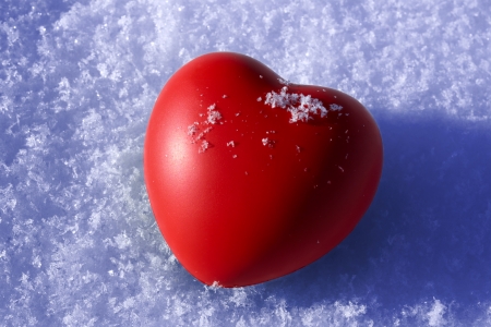 Red heart on white snowの写真素材
