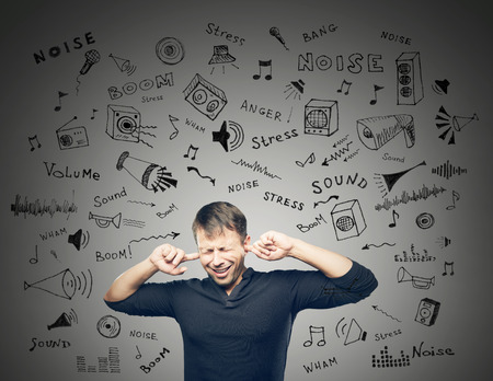 The Young man closed ears on grey background with doodles scetch
