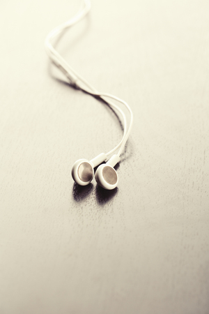 White earphones on wood background with copy spaceの写真素材
