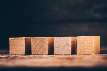 Four Wooden Cubes on Wood Background with Copyspaceの写真素材