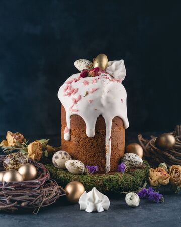 Easter cakes with nest and gold quail eggs on dark background