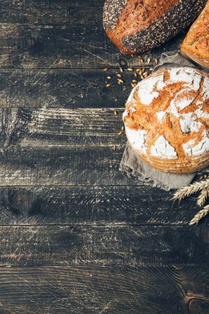 Bread border on wood background with copy space. Different kinds of bread in a corner. Bakery, cooking and grocery store concept.の写真素材