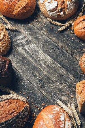Bread border on rustic wooden background with copy space. Different kinds of bread. Bakery, cooking and grocery store concept.の写真素材