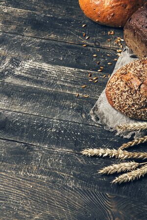 Bread border on wood background with copy space. Different kinds of bread in a corner. Bakery, cooking and grocery store concept.の写真素材
