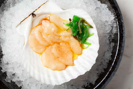 Scallop with chuka seaweed salad served on the plate with ice