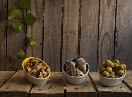 three different tapas appetizers, typical from Spain, olives, sardines and mussels. with a wooden background. summer appetizer.の写真素材