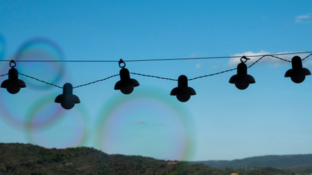 backlit garland with a blue sky background, white clouds and a mountain on the horizon. soap bubbles out of focusERAの写真素材