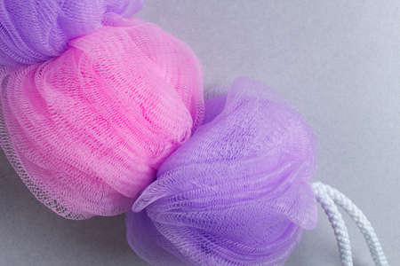 Purple sponge for shower or bath, on gray tilesの写真素材