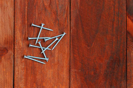 Self-tapping screws on a wooden background. Construction and repairの写真素材
