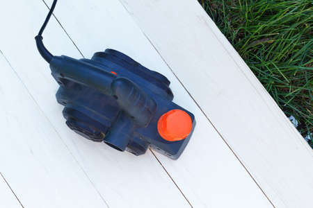 Man sanding wood with orbital sander in workshopの写真素材