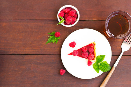 Raspberry pie (cheesecake) made from fresh raspberries with tea on a wooden background. Copy space