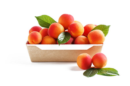 Apricots in paper packaging on a white background. the concept of eco-friendly packaging without plastic.の写真素材