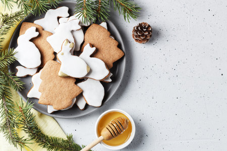 Delicious homemade Christmas cookies in the shape of a rabbit and a Christmas tree on a gray background decorated with New Year's decor. copy spaceの写真素材