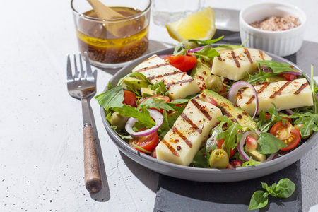 Salad with fried Halloumi cheese, cherry tomatoes, arugula and pomegranate seeds. healthy food. copy spaceの写真素材