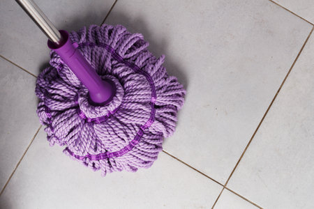 Purple mop on the bathroom floor. The concept of indoor cleaning. copy space.の写真素材