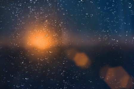 Water drops on a window glass after the rain against the sunsetの写真素材