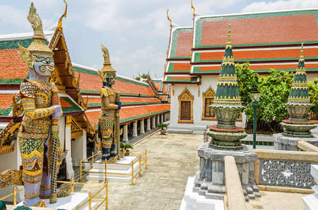 The area of a Buddhist temple complex Wat Pho also known as the Temple of the Reclining Buddha in Bangkok with giant guardian figures at the entrance of one of the buildingsの写真素材