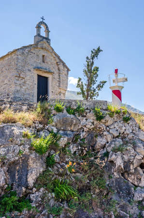 A small old chapel and a light tower of the Institute of Marine Biology in Kotor, Montenegroの写真素材
