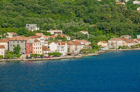 Prcanj - a small town along the Bay of Kotor, Montenegro. A part of the waterfront, that consists of a long line of stone villas.の写真素材