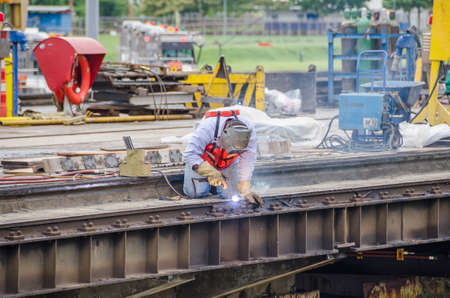Welder making maintenance work on one of the lock gates of Panama Canal, surrounded with welding fumes.の写真素材