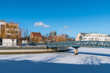Berlin, Germany - February 12, 2021: Frozen Harbor basin Tegeler Hafen with the footbridge, old and modern buildings, Humboldt Library and the clinic Medical Park Humboldtmuehleのeditorial素材