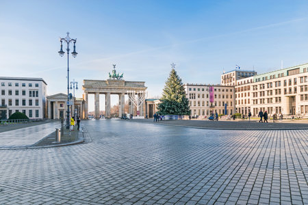 Berlin, Germany - December 18, 2020: Historic square Pariser Platz with the Brandenburg Gate, largest Hanukkah candlestick in Europe and a decorated Christmas treeのeditorial素材