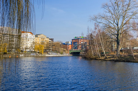 Spree river embankment Bundesratufer in a city district Westphalian quarter (German: Westfaelisches Viertel) with the Lessing bridge and residential buildings, The House Lessing crowned by a mighty triangular gable in Berlin, Germanyの写真素材