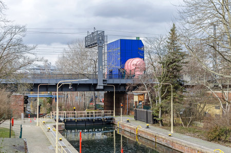 Berlin, Germany - January 31, 2019: The Landwehr Canal, or Landwehrkanal in German bridged by the Berlin Stadtbahn with its Lower Lock and a pink pipe of the circulating channel of the Institute for Water and shipbuilding technologyのeditorial素材