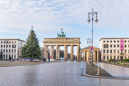 Berlin, Germany - December 18, 2020: Historic square Pariser Platz with the Brandenburg Gate, largest Hanukkah candlestick in Europe and a decorated Christmas treeのeditorial素材