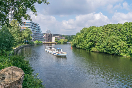 Berlin, Germany - July 3, 2021: Bank of the river Spree Schleswiger Ufer with the tourist boat Maria and recently erected buildings and the tower of the Fraunhofer Institute for Telecommunicationsのeditorial素材