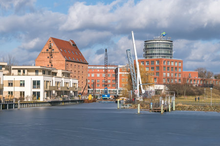 Berlin, Germany - February 19, 2021: Harbor basin Tegeler Hafen with building of the historical mill, now the clinic Medical Park Humboldtmuehle and a footbridge under renovationのeditorial素材