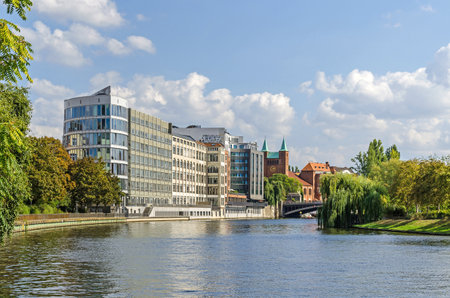 Embankment of the River Spree Wikingerufer with the buildings of Adrema hotel and Protestant Parish Church of the Redeemer and a part of the bridge Gotzkowskybruecke in Berlin, Germanyのeditorial素材