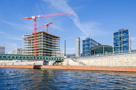 Berlin, Germany - April 22, 2018: Construction boom in the center of Berlin. View of new modern buildings and tower cranes from the river Spree with its Gustav-Heinemann bridge, Rahel Hirsch Street and the Berlin Central Station (Berlin Hauptbahnhof) withのeditorial素材
